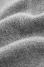 Nahaufnahme der graumelierten Fioroni Cashmere Strickjacke aus reiner Cashmere, feinem Strickbild, Slim Fit, zwei-Wege-Reißverschluss, Rippstrick-Stehkragen und flexiblen Rippbündchen, weich im Griff. Fotografiert aus schräger Perspektive.