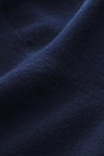 Nahaufnahme des feinen Strickbilds des Fioroni Cashmere Cardigan dunkelblau, reiner Baby-Cashmere mit weichem Griff, glatte Knopfleiste, Regular Fit, flexible Rippbündchen, fotografiert aus seitlicher Perspektive.