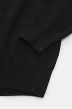 Nahaufnahme des schwarzen Fioroni Cashmere Cardigans aus Italien, Detailansicht von Ärmel und Bund mit feinem Strickbild, weichem Griff, glatter Knopfleiste und flexiblen Rippbündchen, Regular Fit aus reinem Baby-Cashmere.