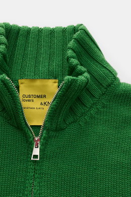 Nahaufnahme der B.F. Knitwear Merino Strickjacke grün mit hochschließendem Stehkragen und Zwei-Wege-Reißverschluss aus reiner Merinowolle, weicher Griff, mittelgrobes Strickbild, Slim Fit, komfortable Rippbündchen, fotografiert von oben.