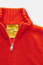 Nahaufnahme der hochschließenden B.F. Knitwear Merino Strickjacke orange mit Zwei-Wege-Reißverschluss, Rippkragen und mittelgrobem Strickbild.