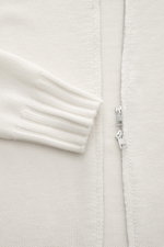B.F. Knitwear Merino Strickjacke offwhite in Nahaufnahme von vorne, zeigt feinmaschiges Strickbild, Zwei-Wege-Reißverschluss, Stehkragen und Rippbündchen.