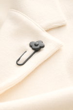 Close-up front view of Lardini Knit blazer cream showing fine knit pattern, soft wool fabric, and black flower pin detail on lapel.

Description: 
<p>With a classic silhouette and made from pure wool, the knit blazer by LARDINI brings style and personalit