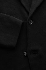 Close-up front view of Lardini Knitted blazer black showing fine knit pattern, two-button slim fit style with lapel and patch hip pocket.

Description: <p>With a classic silhouette and made from pure wool, the LARDINI knitted blazer brings style and perso
