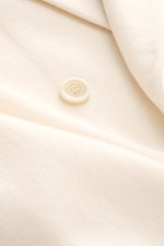 Lardini Knitted blazer cream close-up from above showing fine knit pattern and button detail, pure wool, soft touch, slim fit.