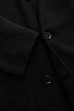 Close-up front view of the Lardini Knitted blazer black, showing fine knit pattern, buttons, and sleeve cuff, knit from pure wool, soft touch, slim fit, double-breasted three-button style, lapel with flower pin, rear side vents, patch hip pockets.