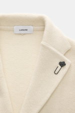 Nahaufnahme des Lardini Cashmere Strickblazer creme, von oben fotografiert, mit feinem Strickbild, fallendem Revers und Blüten-Anstecker.