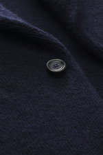 Close-up front view of the dark navy button on the fine knit fabric of the Lardini Cashmere knit blazer 7310.072338-210.

<p>Exquisite knit blazer from LARDINI: This model in smooth, fine pure cashmere knit adds warmth and style to your wardrobe. A pin wi