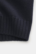 Nahaufnahme der Della Ciana Strickjacke navy, Fokus auf flexible Rippbündchen, mittelfeines Strickbild, weicher Griff, Mix aus Cashmere und Merinowolle, aufgenommen von schräger Seite.