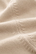 Nahaufnahme der Della Ciana Strickjacke beige aus mittelfeinem Strickbild, mit weichem Griff, Mix aus Cashmere und Merinowolle, Perspektive auf die flexible Rippbündchen.