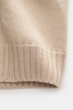 Nahaufnahme der Della Ciana Strickjacke beige, mittelfeines Strickbild, weicher Griff, Mix aus Cashmere und Merinowolle, flexible Rippbündchen.