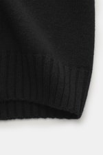 Nahaufnahme der Della Ciana Strickjacke schwarz, Fokus auf mittelfeines Strickbild, weicher Griff, flexible Rippbündchen; Mix aus Cashmere und Merinowolle.