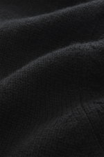 Nahaufnahme der Della Ciana Strickjacke schwarz, Detailansicht des mittelfeinen Strickbilds aus Cashmere-Merinowolle mit weichem Griff.