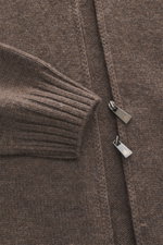 Nahaufnahme der graubraun melierten Della Ciana Strickjacke im Regular Fit, mit weichem Griff, mittelfeinem Strickbild, Stehkragen, Zwei-Wege-Reißverschluss und flexiblen Rippbündchen, fotografiert von schräg oben.