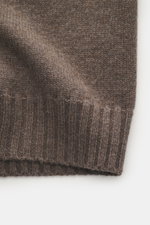 Nahaufnahme der Della Ciana Strickjacke graubraun meliert mit mittelfeinem Strickbild, weichem Griff und flexiblen Rippbündchen, seitlich fotografiert.