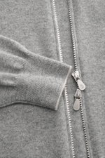 Nahaufnahme der Brunello Cucinelli Cashmere Strickjacke grau meliert von oben, zeigt feines Strickbild, zwei-Wege-Zipper, schmale Kontrastkanten und flexible Rippbündchen, reiner, weicher Cashmere mit anliegendem Stehkragen im Regular Fit.