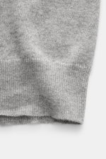 Nahaufnahme der Ärmelkante der Brunello Cucinelli Cashmere Strickjacke grau meliert, mit feinem Strickbild, schmalen Kontrastkanten und flexiblem Rippbündchen, fotografiert aus seitlicher Perspektive.