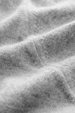 Nahaufnahme der feinen Strickstruktur der Brunello Cucinelli Cashmere Strickjacke grau meliert aus geschmeidigem, reinem Cashmere mit weichem Griff.