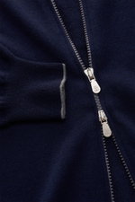 Nahaufnahme der Brunello Cucinelli Cashmere Strickjacke navy von schräg oben, zeigt weichen Cashmere, feine Kontrastkanten am Ärmel, Zwei-Wege-Zipper.