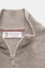 Close-up front view of the Brunello Cucinelli Cashmere cardigan beige melange, showing the fine knit collar and two-way zip.

<p>BRUNELLO CUCINELLI adds a touch of luxury to our casual wardrobe with this cardigan in smooth cashmere, refined with narrow co