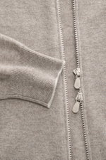 Close-up front view of Brunello Cucinelli Cashmere cardigan beige melange showing fine knit texture, narrow contrasting borders on cuffs, and two-way zip.

Description: <p>BRUNELLO CUCINELLI adds a touch of luxury to our casual wardrobe with this cardigan