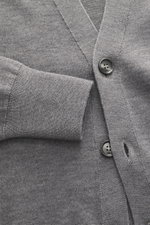 Nahaufnahme des Ami Paris Merino Cardigan grau meliert von schräg oben, zeigt feines Strickbild, V-Neck, Fünf-Knopf-Leiste, Logo-Stitching, weichen Griff und Rippbündchen aus reiner Merinowolle.