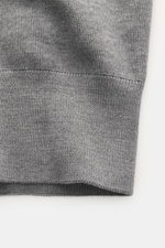 Nahaufnahme des graumelierten Ami Paris Merino Cardigan von unten mit weichem Griff und feinem Strickbild, Regular Fit, Rippbündchen.