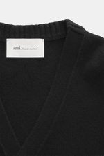 Nahaufnahme des Ausschnitts eines Ami Paris Cashmere Cardigan schwarz, Strick aus Cashmere mit Wollanteil, sehr weicher Griff, mittelfeines Strickbild, Slim Fit, V-Ausschnitt, Fünf-Knopf-Leiste, kleines tonales Herz-Stitching, elastische Rippstrickbündche