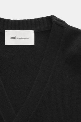 Nahaufnahme des Ausschnitts eines Ami Paris Cashmere Cardigan schwarz, Strick aus Cashmere mit Wollanteil, sehr weicher Griff, mittelfeines Strickbild, Slim Fit, V-Ausschnitt, Fünf-Knopf-Leiste, kleines tonales Herz-Stitching, elastische Rippstrickbündche