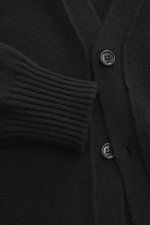Nahaufnahme des Ami Paris Cashmere Cardigan schwarz von oben, mittelfeines Strickbild, Slim Fit, V-Ausschnitt, Fünf-Knopf-Leiste, kleines Herz-Stitching, elastische Rippstrickbündchen, Strick aus Cashmere mit Wollanteil, sehr weicher Griff.
