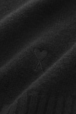 Nahaufnahme des Ami Paris Cashmere Cardigan schwarz, Strick aus Cashmere mit Wollanteil, sehr weicher Griff, mittelfeines Strickbild, kleines tonales Herz-Stitching sichtbar.