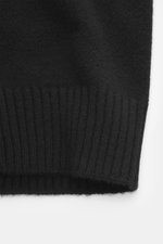 Nahaufnahme des unteren Ärmels mit elastischem Rippstrickbündchen des Ami Paris Cashmere Cardigan schwarz, Strick aus Cashmere mit Wollanteil, sehr weicher Griff, mittelfeines Strickbild, Slim Fit, Fünf-Knopf-Leiste, V-Ausschnitt, kleines tonales Herz-Sti