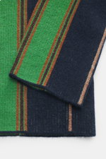 Nahaufnahme von Ärmel und Saum des Guest In Residence Cashmere Cardigan navy/grün/rostbraun gestreift, reiner Cashmere, weicher Griff, mittelfeines Strickbild, Regular Fit, glatte Knopfleiste, V-Neck, von oben fotografiert.