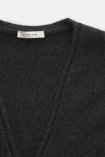 Close-up front view of The Row Cashmere Cardigan 'Manor' dark grey melange, showcasing its coarse knit, soft touch, and ribbed cuffs.