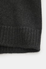 The Row Cashmere Cardigan 'Manor' dark grey melange shown from a close-up side angle, highlighting its coarse knit, ribbed cuffs, and dense, soft cashmere texture. Statement knitwear for the cold season: The voluminous 'Manor' cardigan from THE ROW made o