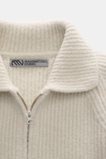 Nahaufnahme der Massimo Osti Studio Strickjacke creme mit Umlegekragen, robustem Reißverschluss, voluminösem Strickbild, Slim Fit, weichem Griff, Mix aus Wolle und Microfaser, fotografiert von oben.
