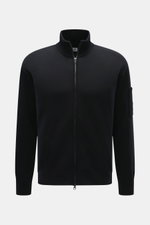 C.P. Company Strickjacke schwarz, Frontansicht, Regular Fit, Strick aus Schurwolle und Microfaser, feines Strickbild, Zwei-Wege-Reißverschluss, Stehkragen, Tasche am Oberarm, Linsen-Detail.