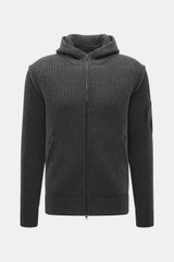 C.P. Company Strickjacke dunkelgrau, frontale Nahaufnahme, Strick aus Schurwolle und Microfaser, weiche Qualität, voluminöses Strickbild, Slim Fit, Zwei-Wege-Reißverschluss, Kapuze, schräge Taschen, Oberarm-Zipper, Linsen-Detail.