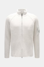 C.P. Company Strickjacke offwhite, frontale Nahaufnahme, Strick aus Schurwolle und Microfaser, weiche Qualität, voluminöses Strickbild, Regular Fit, Raglanärmel, Zwei-Wege-Reißverschluss, Stehkragen, Zipper-Tasche am Oberarm, Linsen-Detail.
