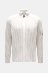 C.P. Company Strickjacke offwhite, frontale Nahaufnahme, Strick aus Schurwolle und Microfaser, weiche Qualität, voluminöses Strickbild, Regular Fit, Raglanärmel, Zwei-Wege-Reißverschluss, Stehkragen, Zipper-Tasche am Oberarm, Linsen-Detail.
