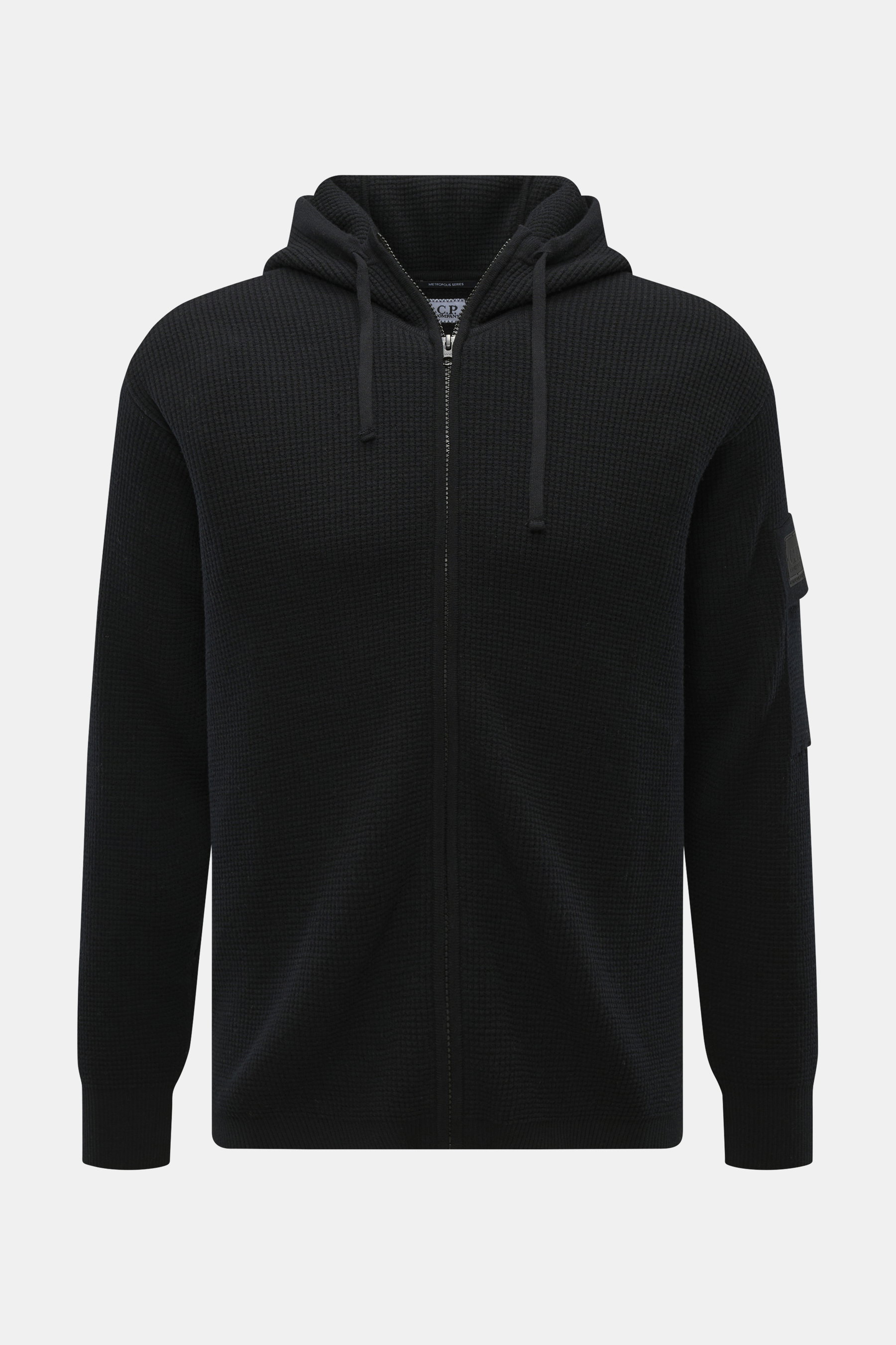 Vorderansicht der C.P. Company Strickjacke 'Metropolis' schwarz aus Schurwolle und Microfaser, Regular Fit, mit Kapuze, robustem Reißverschluss, Tasche am Arm mit Logo-Patch, weichem Griff und flexiblen Rippbündchen.