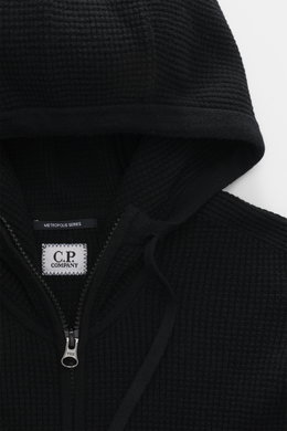 Nahaufnahme der Kapuze und des robusten Reißverschlusses der C.P. Company Strickjacke 'Metropolis' schwarz, Regular Fit, weicher Griff, Mix aus Schurwolle und Microfaser, Kapuze mit Tunnelzug, Tasche am Arm mit Logo-Patch, flexible Rippbündchen.