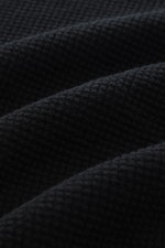 Nahaufnahme der schwarzen C.P. Company Strickjacke 'Metropolis' mit feiner Struktur, Mix aus Schurwolle und Microfaser, weicher Griff, Regular Fit, robuster Reißverschluss, Kapuze mit Tunnelzug, Arm-Tasche mit Logo-Patch und flexiblen Rippbündchen, textil