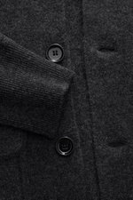 Allude Cardigan dunkelgrau meliert Nahaufnahme von glatter Knopfleiste, Rippbündchen und Fronttasche aus Schurwoll-Cashmere-Mix.