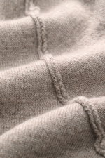 Nahaufnahme des weichen Strickbilds und der Nahtdetails des Allude Cardigan beige meliert aus Schurwoll-Cashmere-Mix, Perspektive von oben.