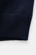 Nahaufnahme des Allude Cardigan navy in Regular Fit, fotografiert von unten, zeigt weiches, feines Strickbild aus Schurwoll-Cashmere-Mix mit Rippbündchen.