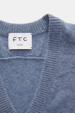 Nahaufnahme des FTC Cashmere Cardigan rauchblau meliert, nachhaltiges Fair-Trade-Cashmere mit weichem Griff und Rippbündchen, von oben fotografiert.