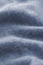 Nahaufnahme des weichen, melierten Strickstoffs vom FTC Cashmere Cardigan rauchblau meliert mit voluminöser, nachhaltiger Fair-Trade-Cashmere-Qualität.