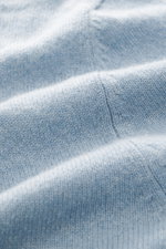 Nahaufnahme der hellblau melierten FTC Cashmere Strickjacke, Detailansicht des feinen Strickbilds aus Fair-Trade-Cashmere, OEKO-TEX® Standard 100 zertifiziert.