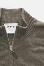 Nahaufnahme der FTC Cashmere Strickjacke graugrün von oben, zeigt gerippten Stehkragen, feines Strickbild, verdeckten Zwei-Wege-Reißverschluss mit Leder-Logo.